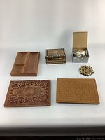 Photo showing assortment of vintage wooden trays and boxes, leather piece, decorative tile and metal trinket holder