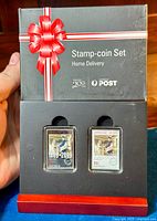 Full set in original packaging with two stamps and framed silver coin visible