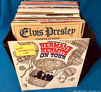 Photo showing the crate packed with vinyl record albums, front album visible Herman's Hermits 'On Tour' and Elvis Presley album behind