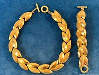 Full view of necklace and bracelet laid flat on blue background