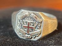 Close-up of ring face showing detailed enamel coat of arms and inscriptions of 'Victoria College' and 'University of Toronto'