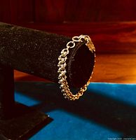 Side angle of the vintage sterling silver triple link charm bracelet showing the butterfly charm and triple link design