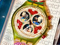 Front view of watch dial and case resting on Swatch-branded background