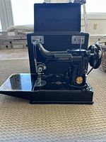 Singer 221-1 sewing machine mounted on base with carrying case lid open