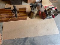Full view of the antique Dunlap mitre box, blow torch, and Craftsman Arco saw laid out on a surface.