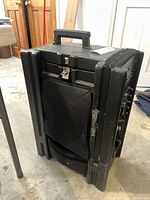 Front and side angled view of the portable sound system showing black rugged case and carry handle