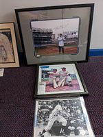 Three framed baseball photos including one with Ron Blomberg signature at Yankee Stadium, Mickey Mantle and Yogi Berra framed photo, and black and white autographed photo of baseball player batting.