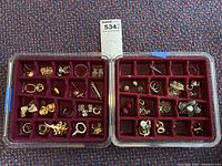 Overview of two plastic jewelry tray halves filled with costume jewelry