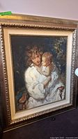 Front view of framed limited edition print depicting mother holding child