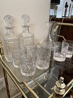 Overview of two crystal decanters with stoppers, four pinwheel-pattern glasses, two plain glasses and wine decanter