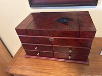 Front view of the cherry wood jewellery box with key on top showing overall condition and drawers.