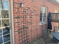 Six trellises leaning against a brick wall, full front view