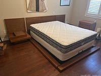 Full view of queen bed frame with mattress and two nightstands