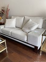 Front view showing full sofa with two seat cushions, three back cushions, two throw pillows