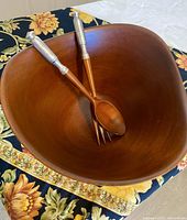Top view inside the mahogany wood salad bowl showing the pair of matching servers inside.