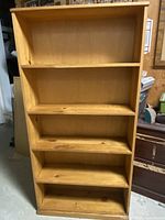 Front view of the natural pine 4-shelf bookcase showing the shelves and wood grain.