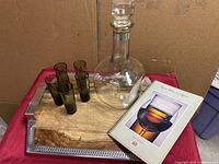Entire set shown on red cloth background including decanter, shot glasses, tray, and book
