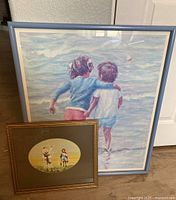 Framed signed print by Ivan Anderson of two children at the beach, pastel colors, large size