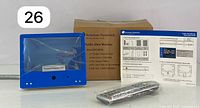 Blue front panel 7-inch monitor with protective plastic film on screen, packaged with original box and accessories including remote control and cables.