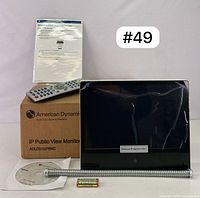 Front view of the monitor with protective film, remote control, manual, box, software CD, metal spring cover, and a Toshiba battery