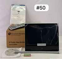 Monitor display with remote, manual, mounting bracket and battery on table with seller's lot label #50