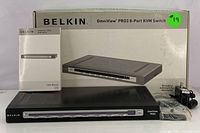 Overview photo of the Belkin OmniView PRO3 8-Port KVM Switch with user manual, power cord, and original box.