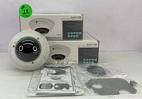 Two boxed Illustra 825 fisheye cameras, one camera outside of box, showing dome design and branding