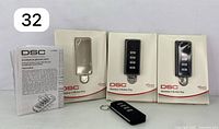 Set of three DSC wireless 4-button remote controls with original boxes and instruction manual.