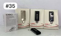 Set of three DSC Wireless 4-Button Key remotes in original packaging, instruction manual included.