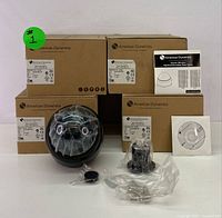 Set of 4 boxed American Dynamics indoor dome cameras with one camera outside box showing the tinted dome and lens, accompanied by an installation guide and software CD.