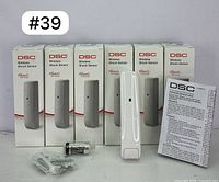 Six DSC Wireless Shock Sensor PG9935 units in boxes, with one sensor and accessories out of the box including screws, anchors, and instruction manual.