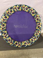Top down view of the trampoline showing the purple jumping mat with Weider lettering and colorful padded edge