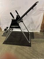 Side angle view of LifeGear inversion table showing the frame, handles, and ankle supports on black mat