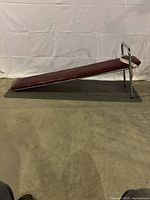 Side view of adjustable incline sit up platform showing the padded wooden surface and steel frame.