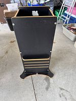 Side view of the black rectangular toddler stool showing the solid side panel and open top