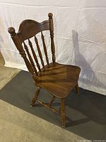 Single solid wood chair showing front angled view with spindle backrest, contoured seat, turned legs and sturdy construction.