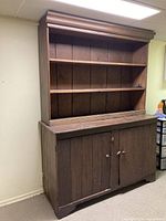 Front view of closed two-piece cupboard showing upper shelves and lower doors