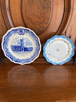 Two vintage plates displayed on a wooden chair, showing front and back views; larger blue and white commemorative University of Western Ontario plate and smaller blue scalloped English plate