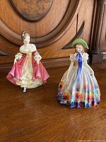 Front view of Southern Belle and Easter Day figurines showing detailed dresses and painted features.