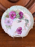 Front view of hand painted Limoges plate showing floral decoration and ornate edges