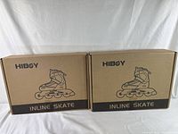 Two unopened cardboard boxes with Hiboy branding and illustration of inline skates, indicating new inline skates lot of 2.