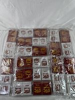 Lot of 48 sealed USC Trojans playing card decks arranged in rows on a white surface.