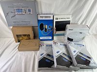 Overview photo showing all items in their packaging including Smartro RF wireless system, microphone pop screen, LCD writing tablet, Robo vacuum cleaner, Nicewell kitchen scales.