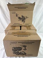 Box showing four packed toy garbage trucks and the electric drill and remote control included in the set.