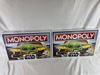 Two sealed Monopoly board game boxes featuring The Child (Grogu) from Star Wars The Mandalorian, showing front artwork and branding.