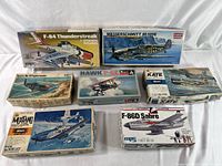 Overview photo showing all seven vintage airplane model kits with varied artwork and kit brands