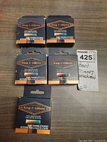 Five boxed King-C-Gillette Style Master Blade Beard Trimming Attachments arranged on a wooden surface with a MaxSold tag.