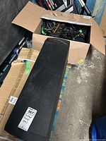 Side view of Acoustimass module next to box of cables, showing identification sticker