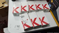 Eight white retail boxes with red “K” graphic labeled “K42” arranged on a table.