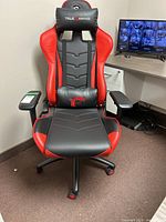 Front view showing red and black upholstery, neck pillow and lumbar cushion